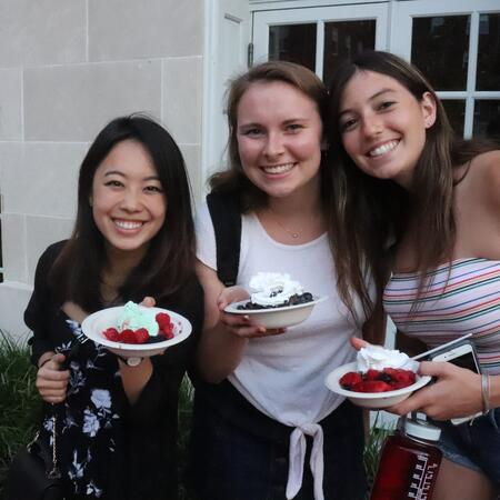 students holding berries and whipped cream