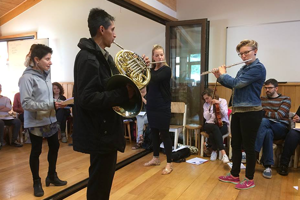 students playing a french horn and a flute