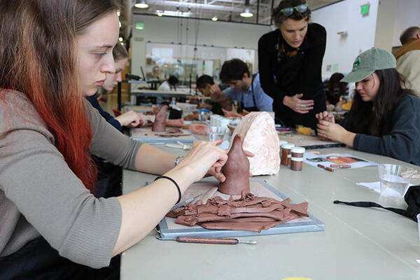 student sculpting clay