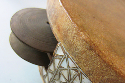 Close up of a tambourine with mother-of-pearl inlay.