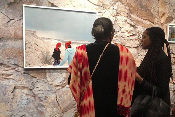 two women look at photography exhibition.