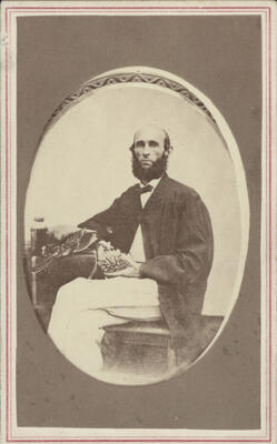 formal portrait of Andrew Garrett holding a coral specimen