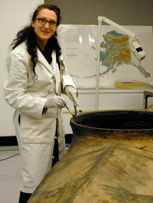 conservator with alutiiq kayak in the gallery.
