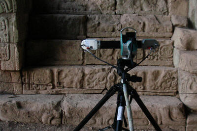 3D scanner mounted on a tripod in front of an inscription