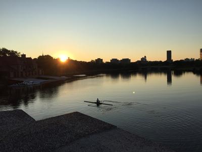a person kayaks on the Charles River at sunrise