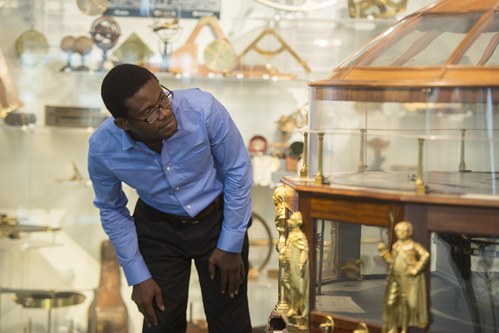 Man looking at a scientific instrument in a gallery.