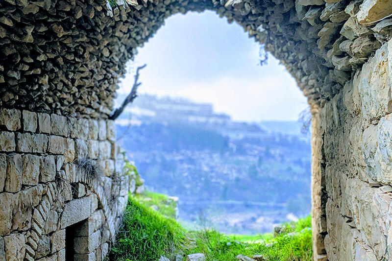 Views of distant landscape through a stone arch