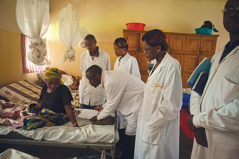 Doctors examine a woman in an African clinic setting