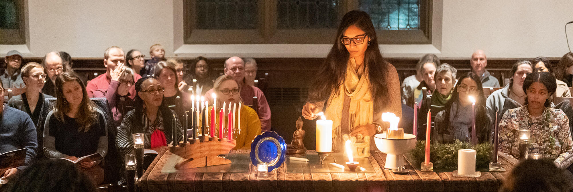 HDs student lighting a candle during the 2019 Seasons of Light service