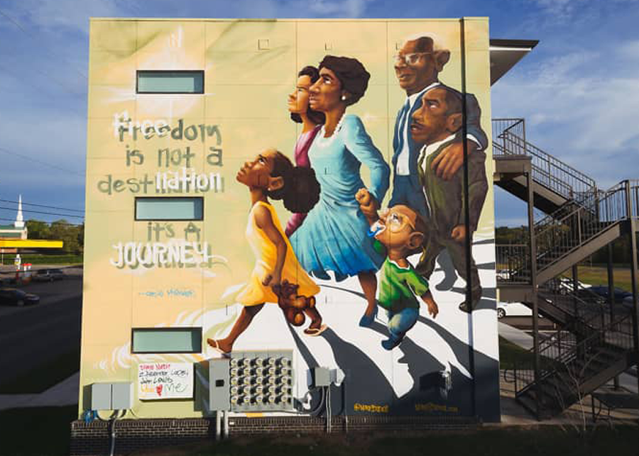 Mural of a family walking and looking up next to the words: Freedom is not a destination it's a Journey"