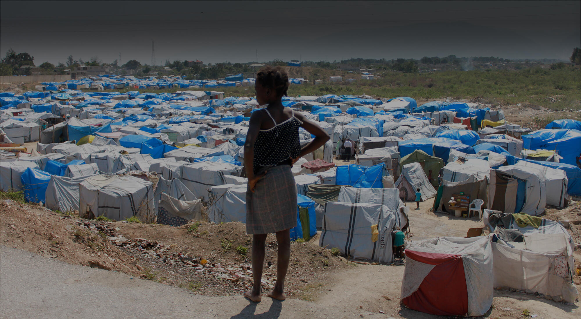 woman standing above a tent camp