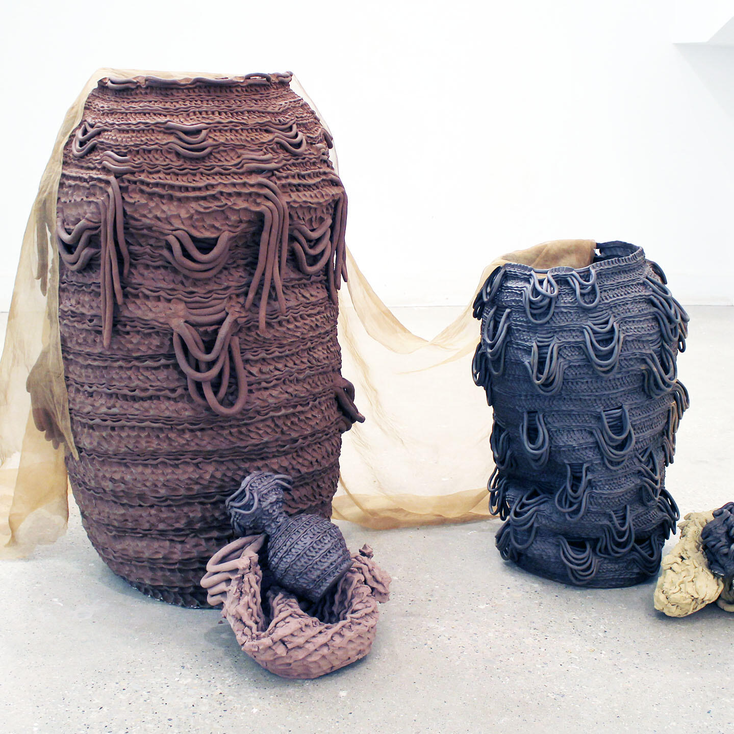 Coiled pots of different colors and fabric by Shea Burke.
