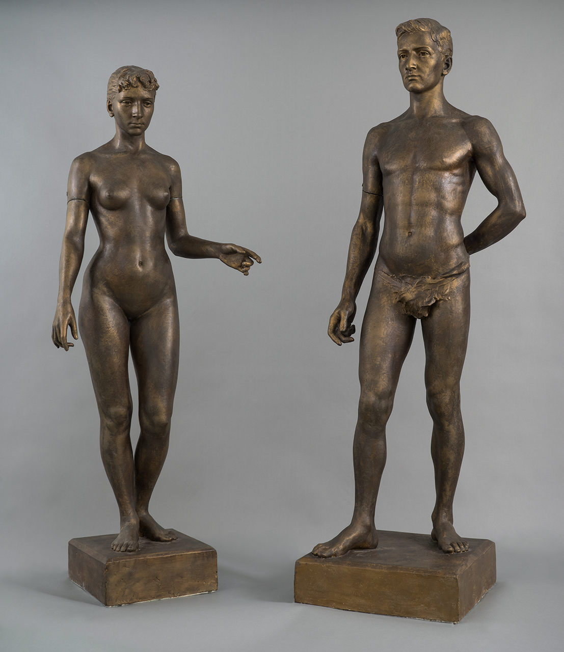pair of life-sized nude male and female statues.