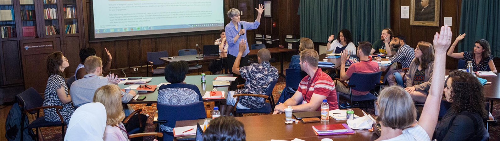 Diane Moore teaching a class, students with raised hands