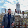 Ryan Pierannunzi poses in front of Harvard skyline