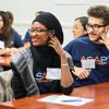 Two students sitting at a desk smile during a CUNY ASAP community session