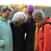 Sally Hammel (left), Laurie Sedwick, Angie Cecil and Gretchen Legler embrace following their sunrise pilgrimage to Walden Pond in November. Photo by Jeffrey Blackwell, Memorial Church