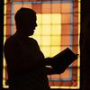 Shadow of man in front of stained glass in Maine church. AP photo