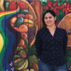 Blanca Morales Temich standing against a mural. Image: Alma Oñate